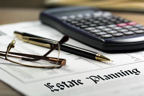 Glasses, black pen and calculator sit on top of paperwork titled Estate Planning